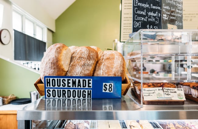 Homemade sourdough in a blue box on a cafe counter.