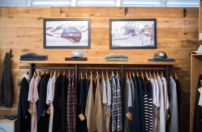Clothing rack in front of a wooden wall.