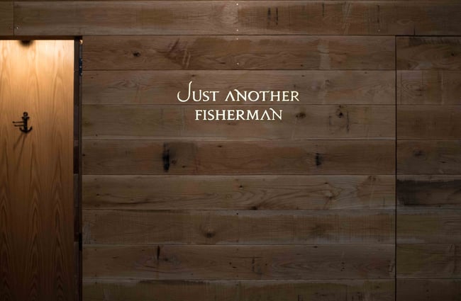 Just Another Fisherman sign on a wooden wall.