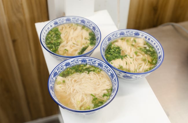 Three bowls of noodles on a table at FJ Noodles & Dumplings.