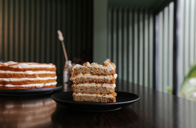 Close up of a slice of cake with lots of icing.