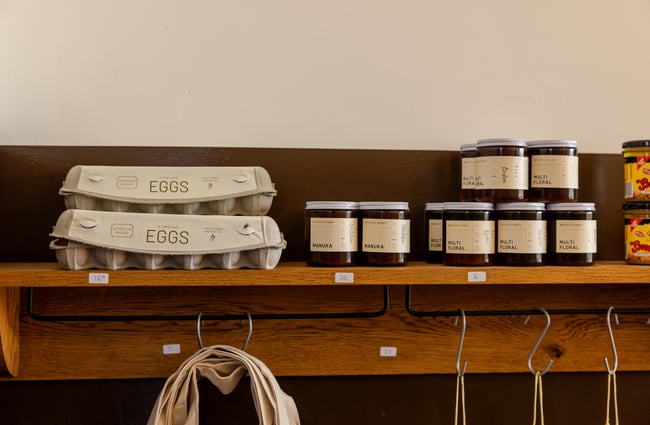 Eggs and jam for sale on floating shelves.