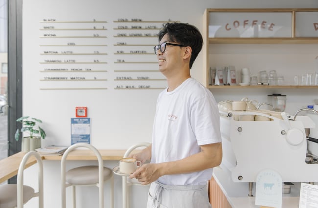 Barista serving a coffee at Fluffy Bake Shop.