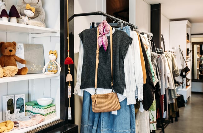 Clothes on racks inside a store.