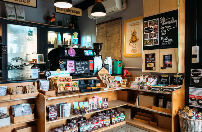 Counter at artisan food shop with coffee machine and various artisan products