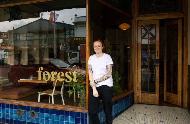 A woman standing outside her restaurant in Auckland.