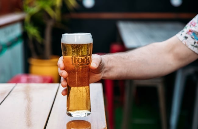 Pint being placed on a table at Fork & Brewer.