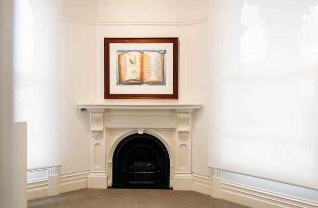 Preserved fireplace feature with artwork above at Forrester Gallery in Ōamaru