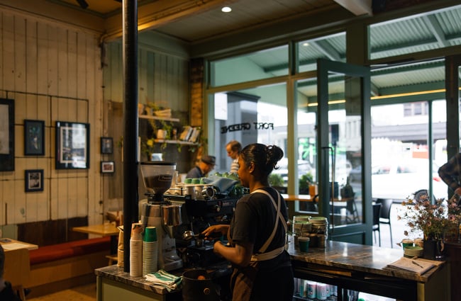 A staff member working behind the coffee machine at Fort Greene.