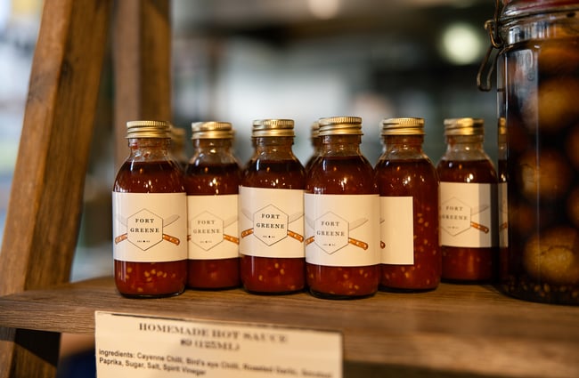 A close up of bottles of chilli bottles on a display.