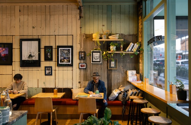 Customers sitting at tables inside a cafe.