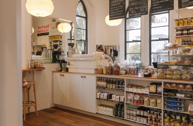 Cafe counter and shelves lined with pantry goods inside Frances Nation Café.