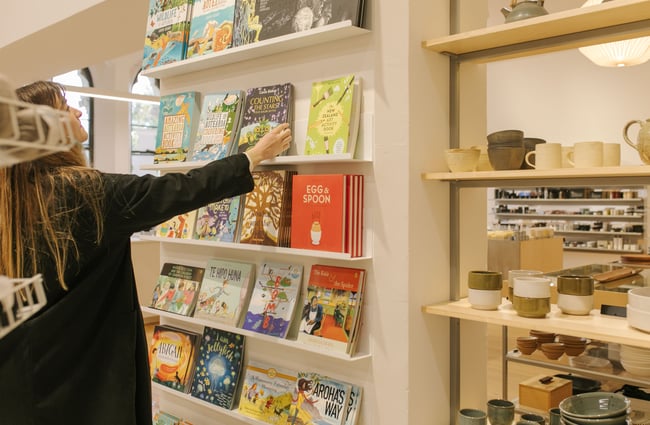 Woman browsing books on the shelf at Frances Nation Home.