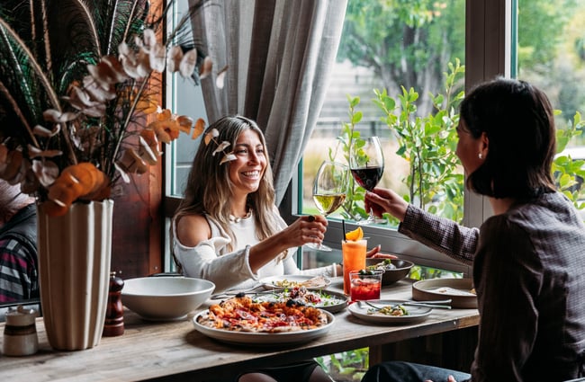 Two customers are holding up their glasses of wine at Francesca.