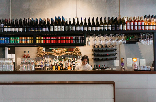 A female staff member working behind a bar.