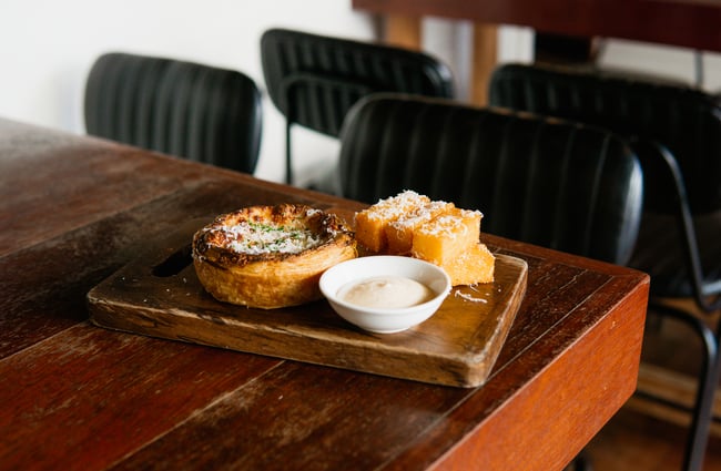 A close up of a pie and polenta on a table.