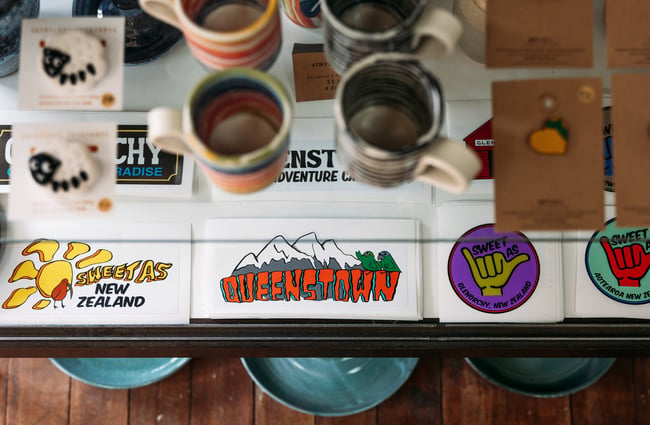 "Queenstown' stickers' on a table.