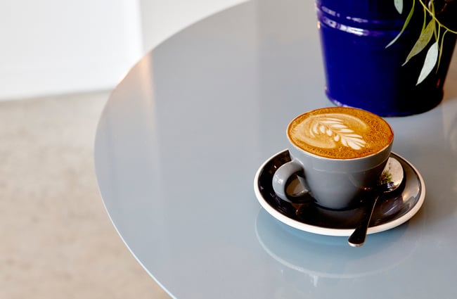A flat white on a table inside Frank's Newtown cafe in Newtown Wellington.