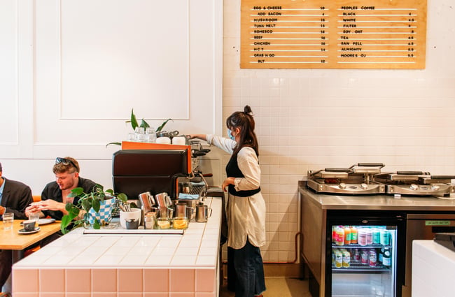 Woman making a coffee at Fred's, Wellington.