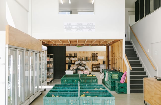 A row of green produce tubs creating an isle down the middle of the room.