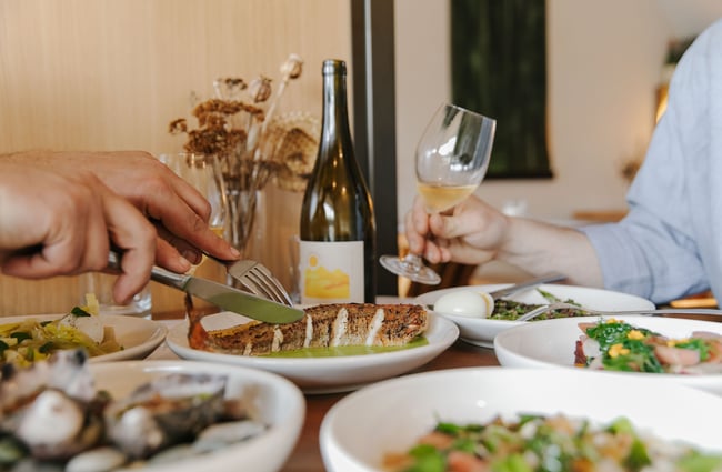 Close up of a customer cutting into cooked fished at Gatherings in Christchurch.