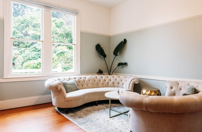 White sofas and large windows at Gear Homestead.