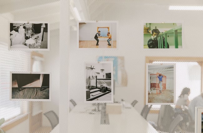 Images displayed on a wire wall divider in the middle of the General Service work space.