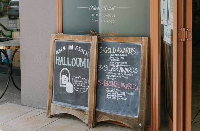 Chalkboard advertising halloumi outside Geraldine Cheese Company.
