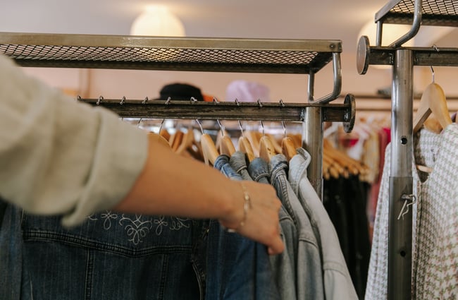 A hand holding vintage denim jackets.