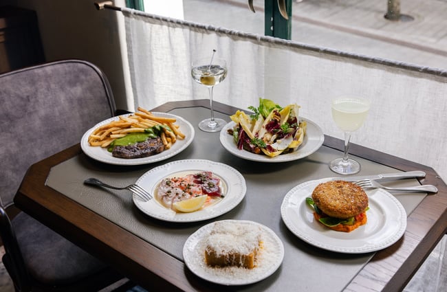 Plates of food on table by window at Gilt Brasserie in Auckland