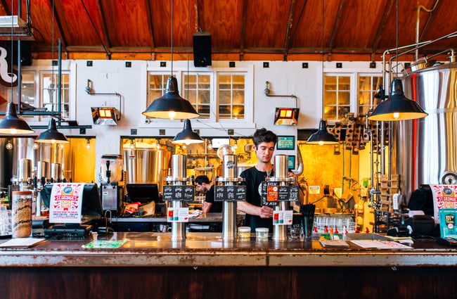 Bartender behind the bar at Good George Dining Hall, Hamilton.