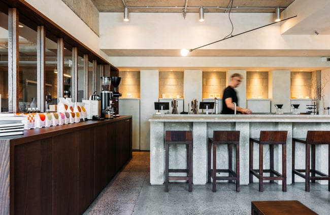 A man walking behind a cafe counter.
