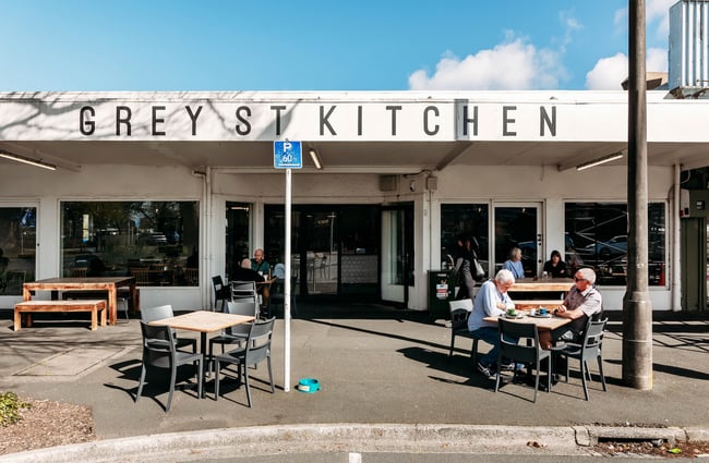The exterior of Grey Street Kitchen with tables and chairs on the footpath in the sun.