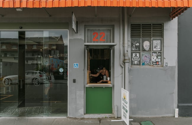Entrance to The Welder with Grizzly Baked Goods' little exterior window service hatch open to the side.