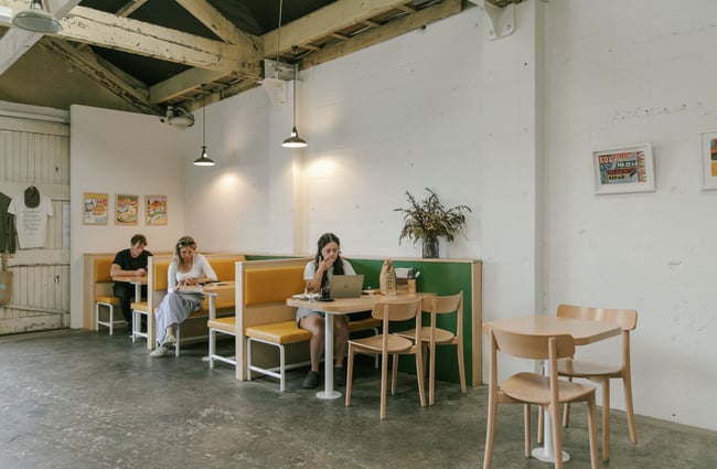 Customers dining and waiting at the booth seating area at Grizzly in The Welder.