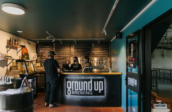 Customer standing at the bar area at Ground Up Brewing, Wānaka.