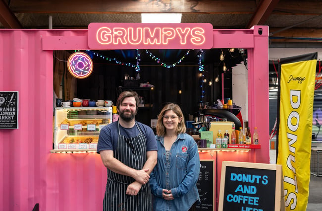 Owners stand in front of the hot pink shipping container at Grumpys.