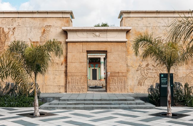 The tall sandstone-coloured walls at the entrance to the Ancient Egyptian Garden.