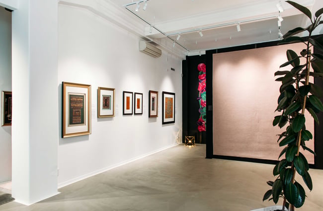 Small works of art on display against a white wall.