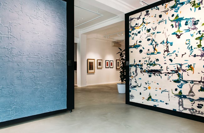 Two giant rugs on display like paintings inside Hanrad Bespoke Rugs.
