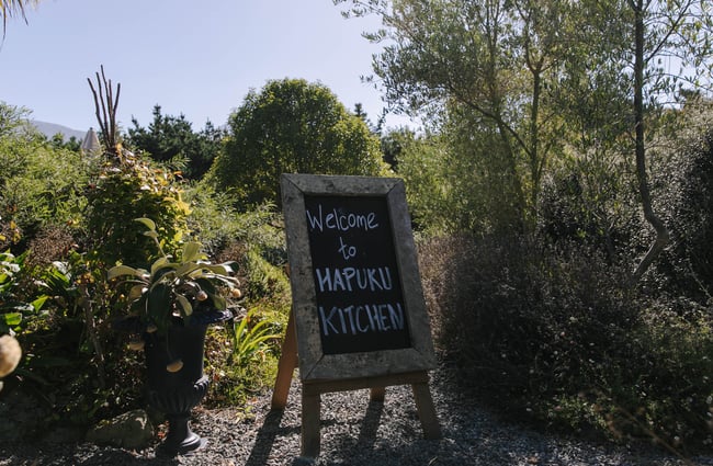 Hapuku Kitchen a-frame sign in the garden.