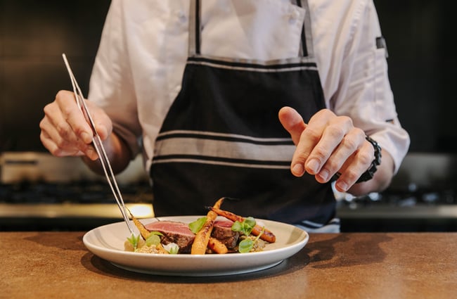 Chef preparing main course at Hapuku Lodge.