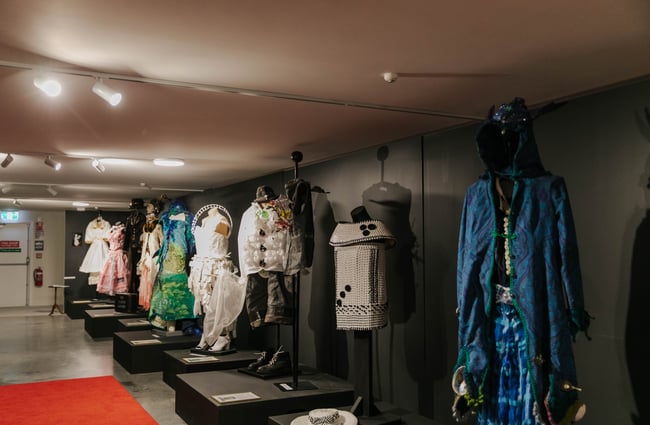 Old vintage clothing on mannequins all lined up in a row.