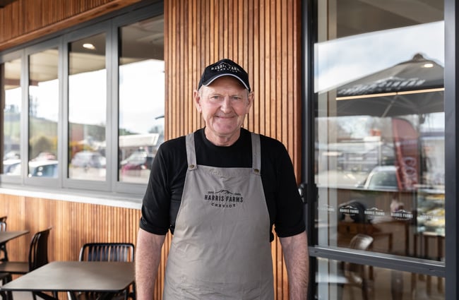 Man with a Harris Farms apron on is standing outside Harris Farms Butchery, Bakery & Café.
