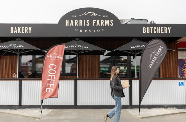 A customer is walking past the entrance to Harris Farms Butchery, Bakery & Café.