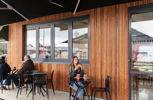 Customer sitting at an outdoor table at Harris Farms Butchery, Bakery & Café.