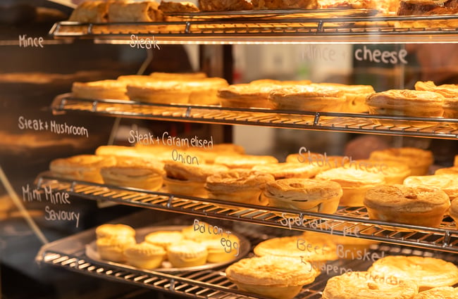 Lineup of pies in the pie warmer at Harris Farms Butchery, Bakery & Café.