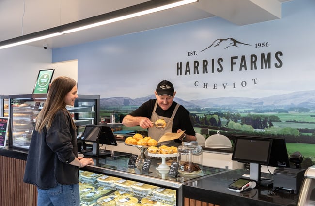 Staff member behind the counter serving a customer at Harris Farms Butchery, Bakery & Café.