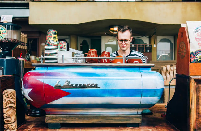 View of the coffee machine with man standing behind.