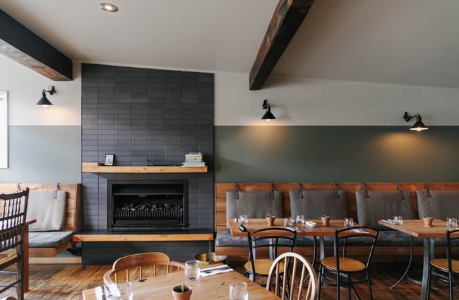 A fireplace and tables and chairs.